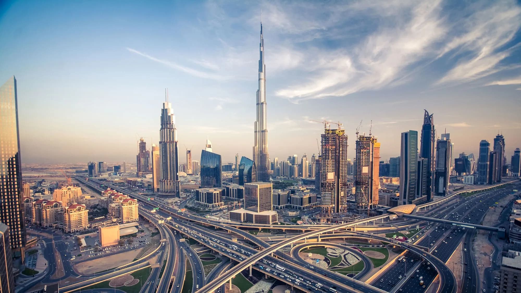 View of the Dubai skyline with the Burj Khalifa towering over the city during sunset